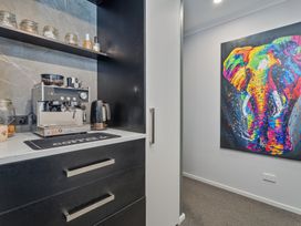 A kitchenette with a coffee machine and jars at Endeavour Oasis - Whitianga Holiday Home Whitianga