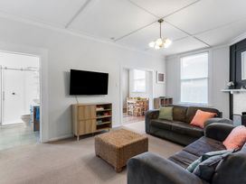 A living room with a sofa and television at Auckland Holiday Home in Auckland