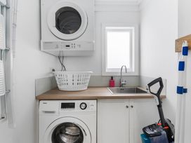 A laundry room with a washing machine and dryer at Auckland Holiday Home in Auckland