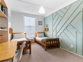 A bedroom with two beds and a desk at Auckland Holiday Home in Auckland