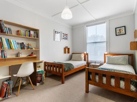 A bedroom with two beds and a desk at Auckland Holiday Home in Auckland