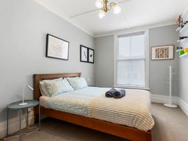 A bedroom with a bed and wall art at Auckland Holiday Home in Auckland