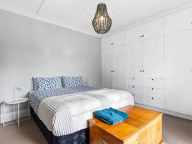 A bedroom with a bed and storage cabinet at Auckland Holiday Home in Auckland
