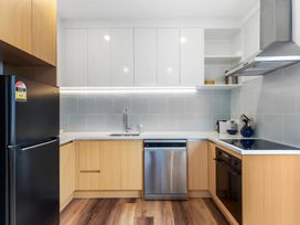 A kitchen with appliances and cabinetry at Auckland Holiday Home in Auckland