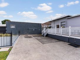 An outdoor area with a concrete driveway and a deck at Auckland Holiday Home Auckland