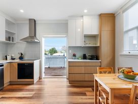 A kitchen with cabinets and a dining table at Auckland Holiday Home in Auckland