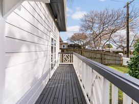 A deck area with railing and trees at Auckland Holiday Home in Auckland
