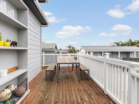 An outdoor dining area with a table and benches at Auckland Holiday Home in Auckland