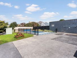 An outdoor area with a swimming pool and picnic table at Auckland Holiday Home in Auckland