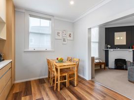 A dining room with a table and chairs at Auckland Holiday Home in Auckland