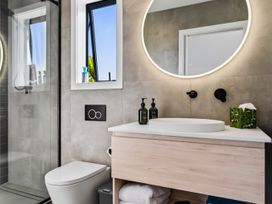 A bathroom with a shower and sink at Mangawhai Holiday Home in Mangawhai