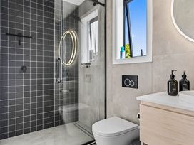 A bathroom with a shower, toilet, and sink at Mangawhai Holiday Home in Mangawhai