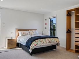A bedroom with a bed and nightstand at Mangawhai Holiday Home in Mangawhai