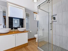 A bathroom with two sinks and a shower at Hannan House - Whitianga Holiday Home