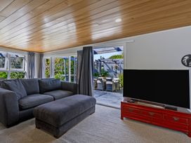 A living room with a sofa and television at Hannan House - Whitianga Holiday Home