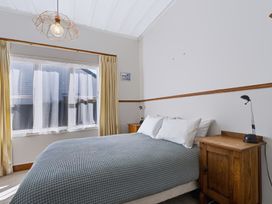 A bedroom with a bed and side tables at Hannan House - Whitianga Holiday Home