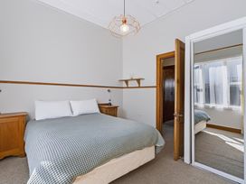 A bedroom with a bed and nightstand at Hannan House - Whitianga Holiday Home
