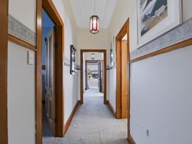 A hallway with doors and light fixtures at Hannan House - Whitianga Holiday Home