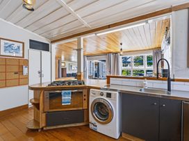 A kitchen with a gas stove and washing machine at Hannan House - Whitianga Holiday Home