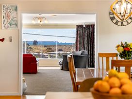 A living room with a view of the ocean at Ohana - Papamoa Holiday Home Papamoa