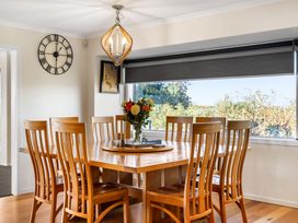 A dining room with a round table and chairs at Ohana - Papamoa Holiday Home in Papamoa