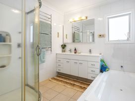 A bathroom with a shower and bathtub at Ohana - Papamoa Holiday Home in Papamoa