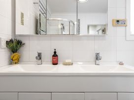 A bathroom with two sinks and a mirror at Ohana - Papamoa Holiday Home Papamoa
