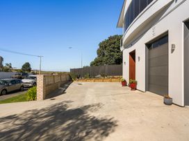 An outdoor area with a driveway and garage door at Ohana - Papamoa Holiday Home, Papamoa