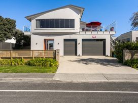 A house with a garage and balcony at Ohana - Papamoa Holiday Home in Papamoa