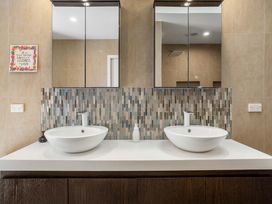A bathroom with dual basins and mirrors at Ohana - Papamoa Holiday Home, Papamoa
