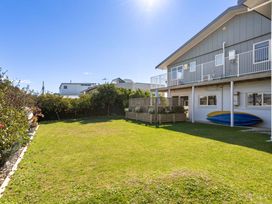 A garden with a lawn and kayaks at Ohana - Papamoa Holiday Home in Papamoa