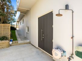 An outdoor area with a door and a showerhead at Ohana - Papamoa Holiday Home Papamoa