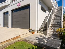 An exterior view of garage doors and stairs at Ohana - Papamoa Holiday Home in Papamoa