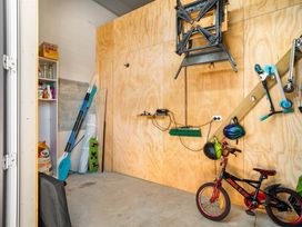 A garage with storage shelves and bicycles at Ohana - Papamoa Holiday Home