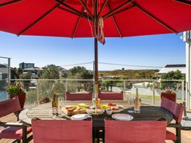 An outdoor dining area with a table and food at Ohana - Papamoa Holiday Home