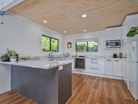 A kitchen with a sink, stove, and refrigerator at Skipper’s view - Onemana Holiday Home in Onemana