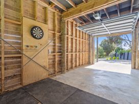 A garage featuring a dartboard and an open garage door at Skipper’s view - Onemana Holiday Home, Onemana