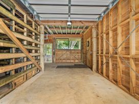 A garage with wooden walls and a concrete floor at Skipper’s view - Onemana Holiday Home in Onemana