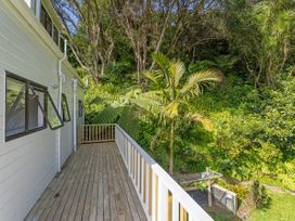An outdoor area with a deck and palm tree at Skipper’s view - Onemana Holiday Home in Onemana
