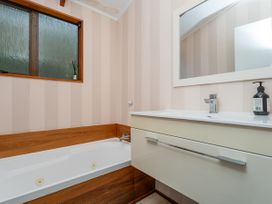 A bathroom with a bathtub and sink at Skipper’s view - Onemana Holiday Home, Onemana