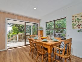 A dining room with a wooden table and chairs at Skipper’s view - Onemana Holiday Home in Onemana