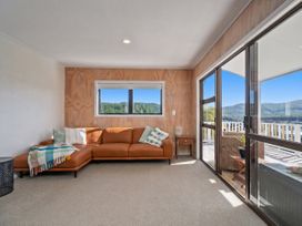 A snug with a sofa and window at Skipper’s view - Onemana Holiday Home in Onemana