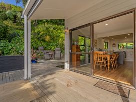 An outdoor area with a deck and a view of the kitchen at Skipper’s view - Onemana Holiday Home Onemana