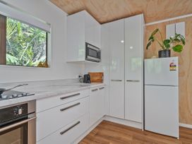 A kitchen with modern appliances and cabinetry at Skipper’s view - Onemana Holiday Home, Onemana