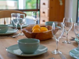 A dining table set with plates and glasses at Skipper’s view - Onemana Holiday Home, Onemana