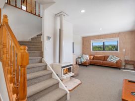 A living room with a sofa and fireplace at Skipper’s view - Onemana Holiday Home in Onemana