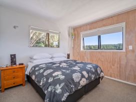 A bedroom with a bed and a bedside table at Skippers View - Onemana Holiday Home, Onemana