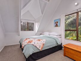 A bedroom with a bed and window at Skippers View - Onemana Holiday Home in Onemana