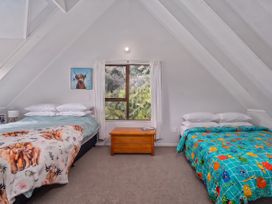 A bedroom with two beds and a table at Skippers View - Onemana Holiday Home