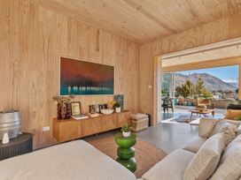 A living room with a sofa, coffee table, and artwork at Peak Perspective - Wanaka Holiday Home in Wanaka